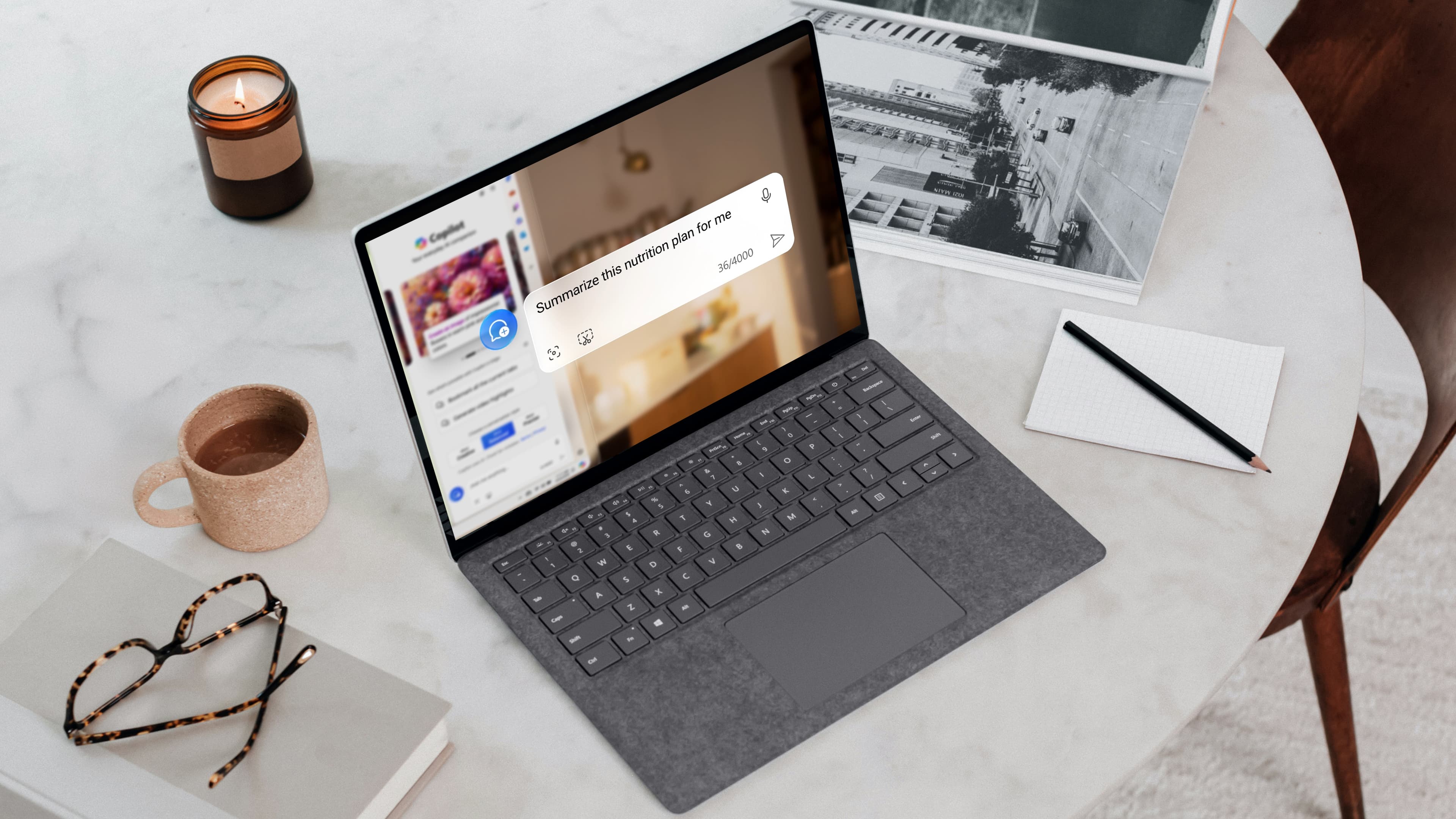 Microsoft Surface laptop on a marble table displaying the Microsoft Edge Copilot sidebar with the prompt "Summarize this nutrition plan for me." A candle, coffee cup, book with glasses, and notepad with pencil are nearby.