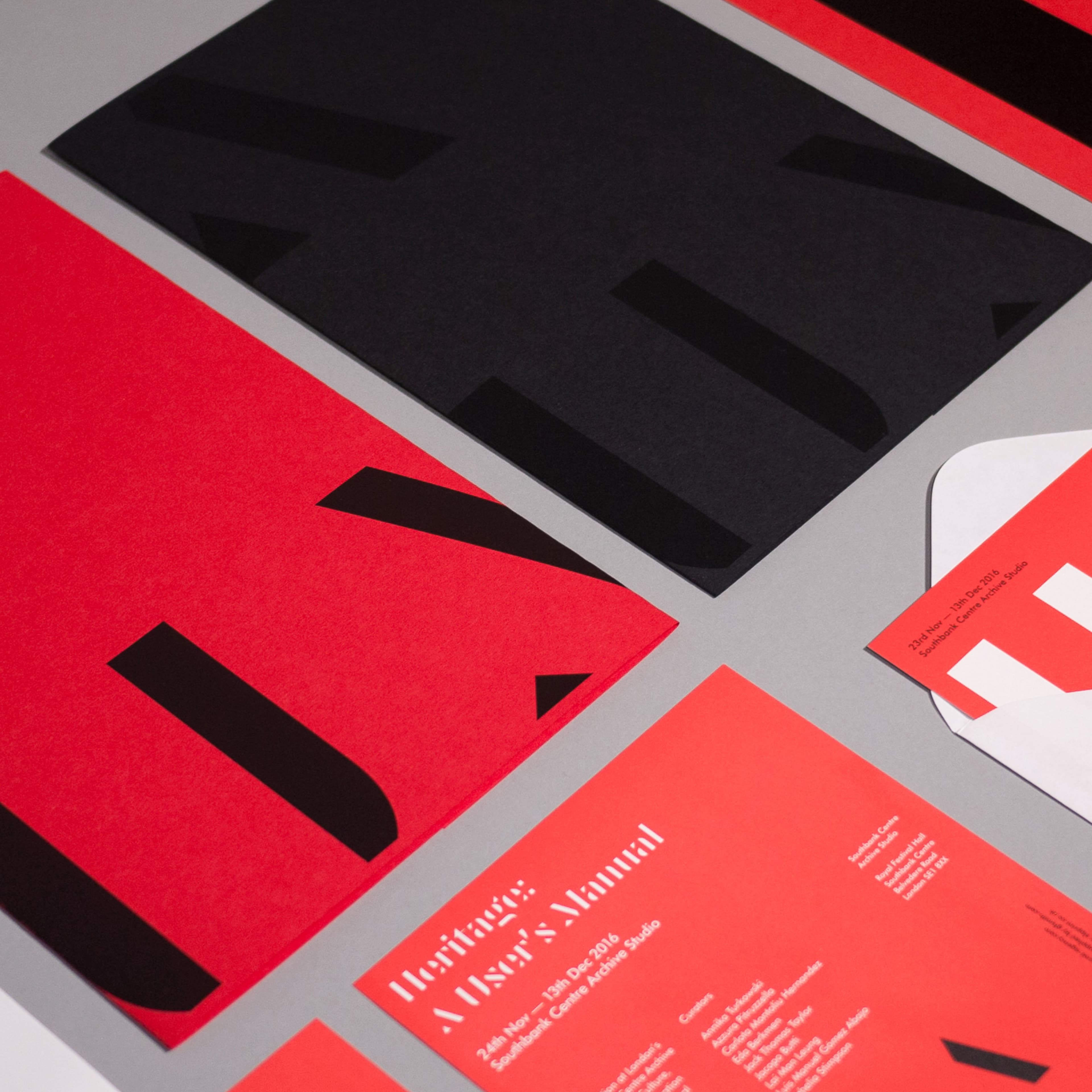 Printed collateral for "Heritage: A User's Manual" exhibition at Southbank Centre Archive Studio, 24 Nov–13 Dec 2016, featuring bold red and black typography across posters, flyers, and an envelope on a gray surface.