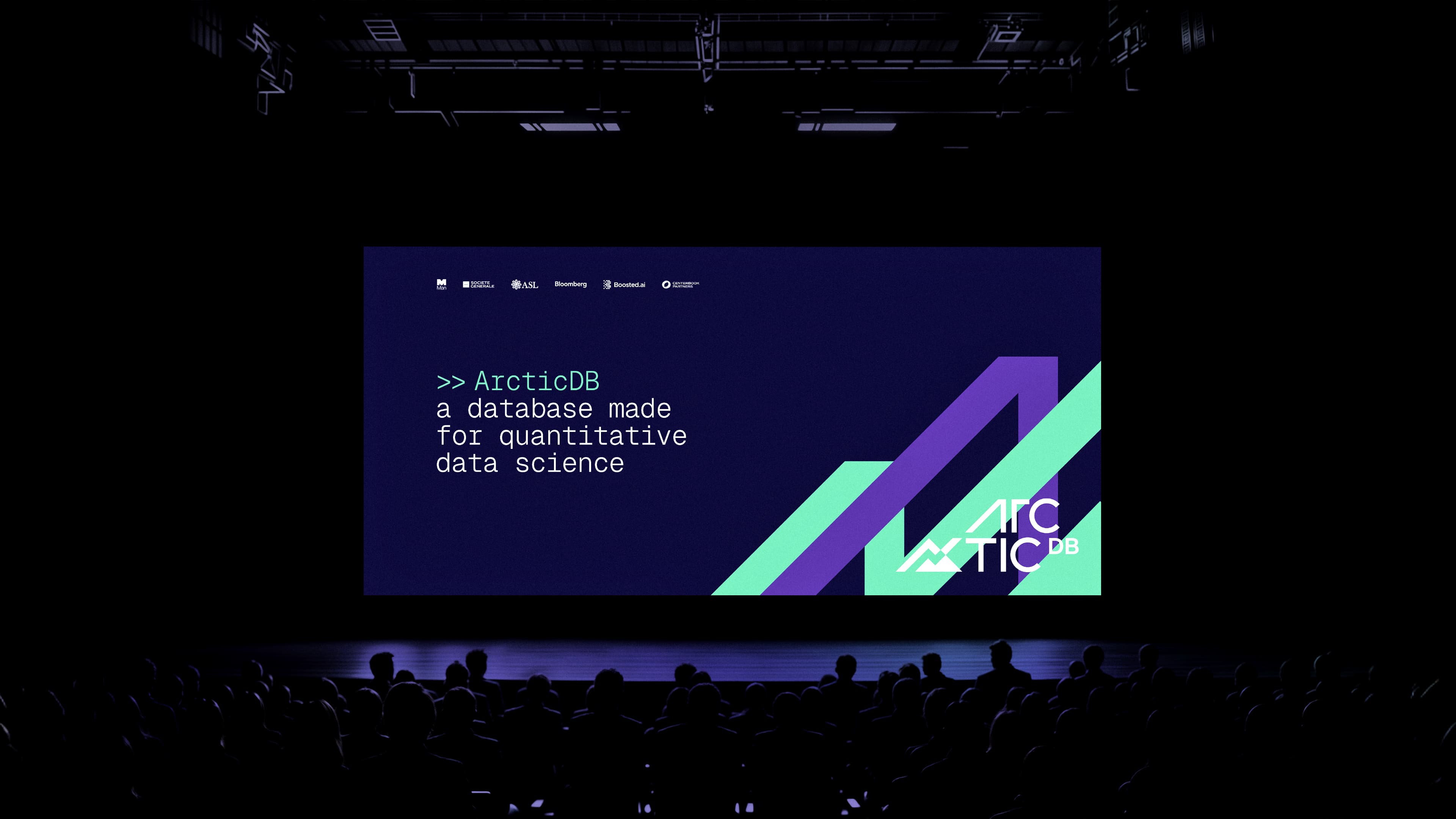 Silhouettes of an audience watching a presentation about ArcticDB, a database for quantitative data science, on a dark stage.