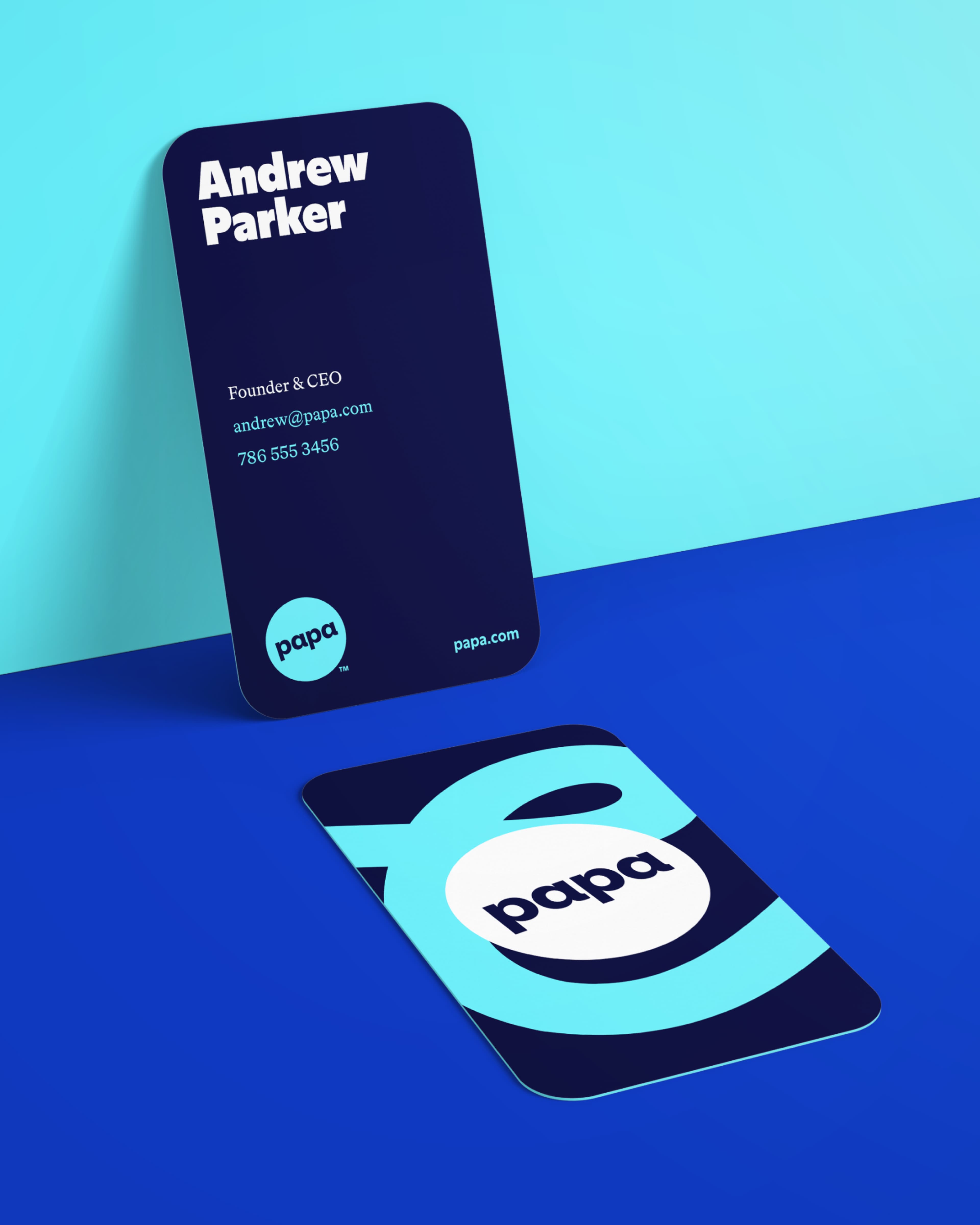 Two navy business cards for Andrew Parker, Founder & CEO of Papa, showing contact details (andrew@papa.com, 786 555 3456, papa.com) on the front and the Papa logo on the back, displayed on a blue surface.