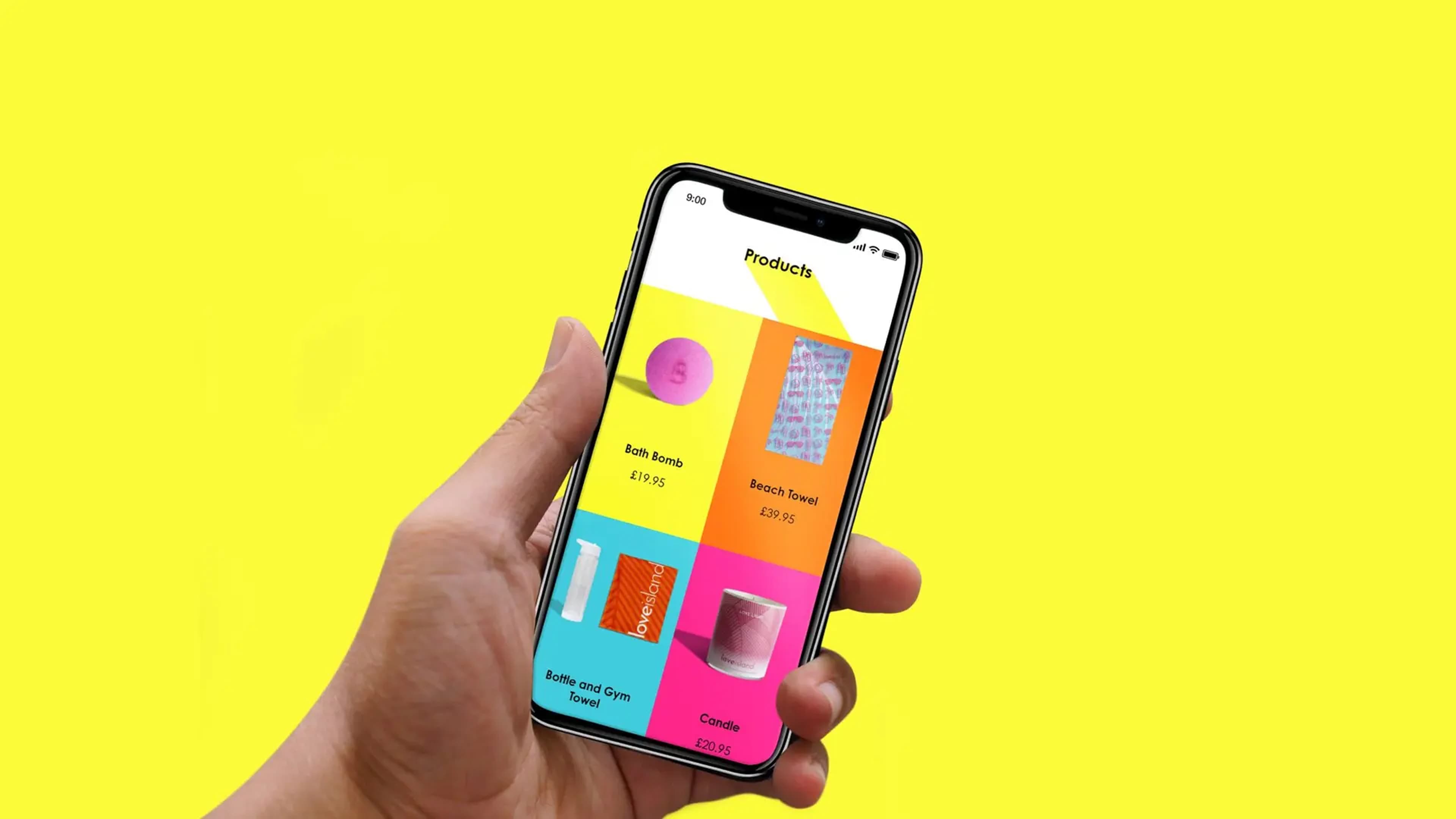 Hand holding a smartphone displaying a Love Island shopping app product page, showing items including a Bath Bomb (£19.95), Beach Towel (£39.95), Bottle and Gym Towel, and Candle (£20.95), against a yellow background.