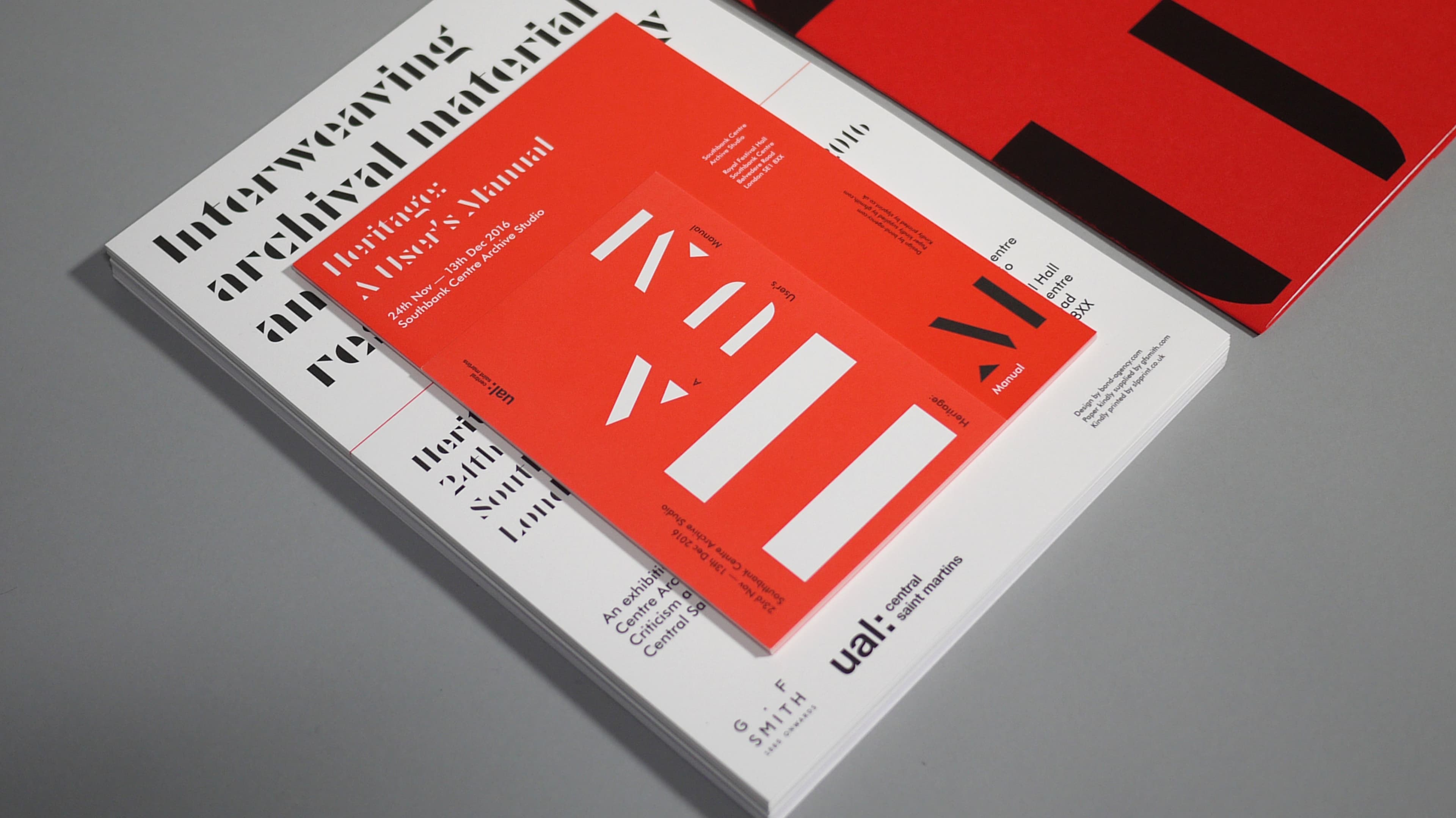 Stack of printed publications for "Heritage: A User's Manual," an exhibition at Southbank Centre Archive Studio, 24 Nov–13 Dec 2016, featuring bold red and white graphic design with UAL Central Saint Martins branding.