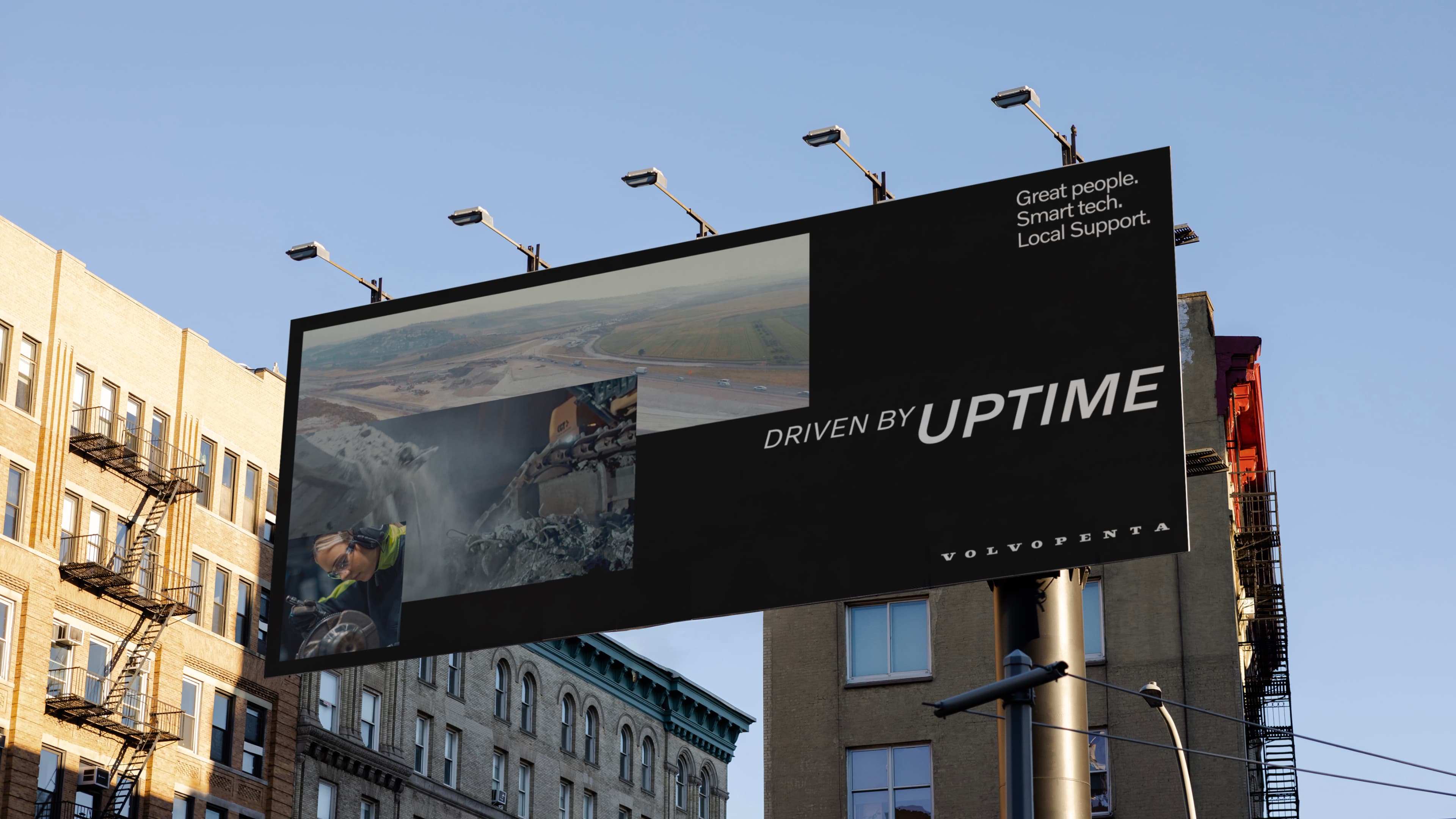 A picture of a billboard outside with the text Driven By Uptime on it and a blue skied background.